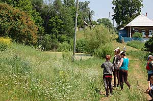 Справа от улицы в низине пруд
