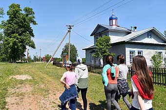 Туристы проходят мимо храма Рождества Пресвятой Богородицы